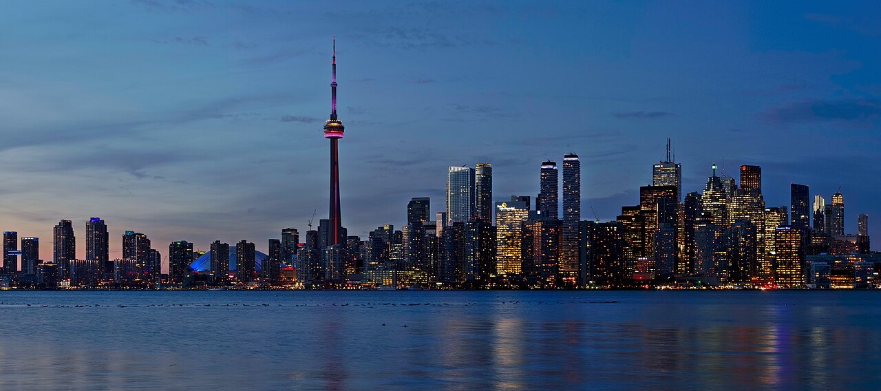 Toronto skyline at dusk, including the CN Tower and Rogers Centre dome, photographed from the islands in 2018